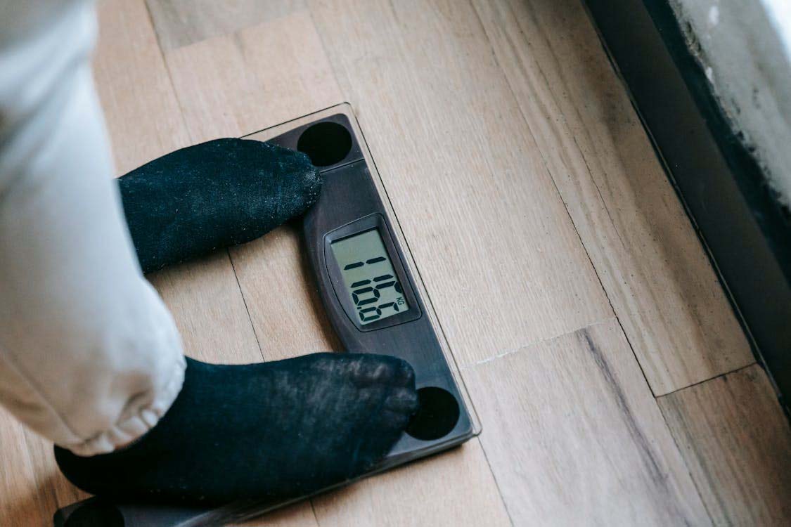 Individual weighing themself on a weight scale